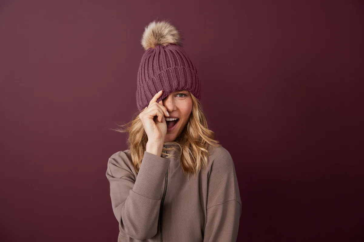 Port Authority Faux Fur Pom Beanie — Style C990 in Rosewood — manufacturer lifestyle photo