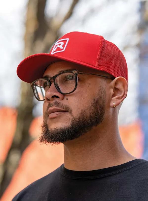 Man wearing a red Richardson trucker cap with a white embroidered R logo