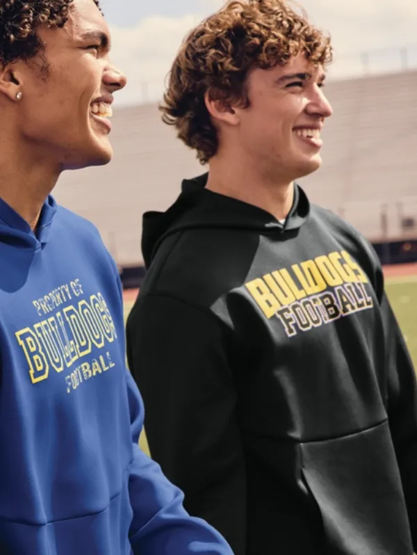Two team members wearing blue and black pullover hoodies with printed Bulldogs graphics