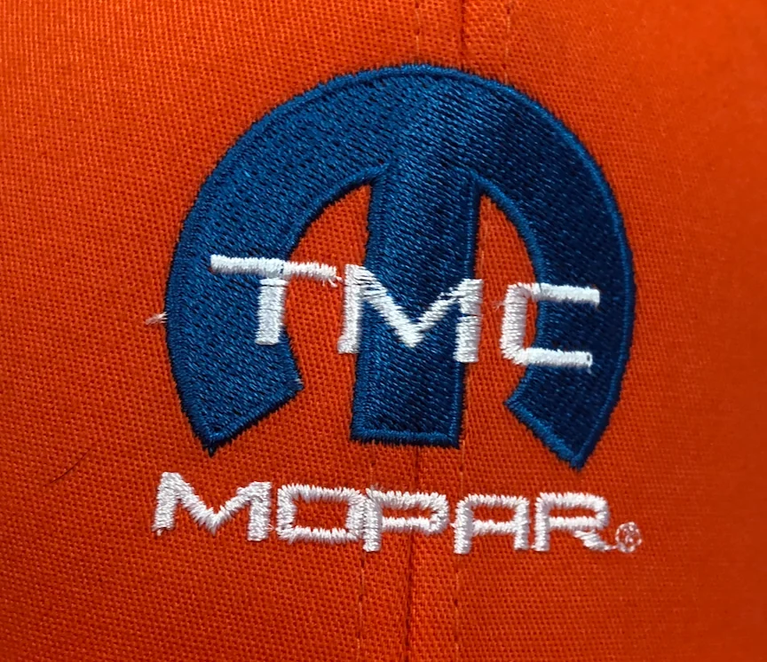 White and blue MOPAR logo embroidered on orange knit fabric