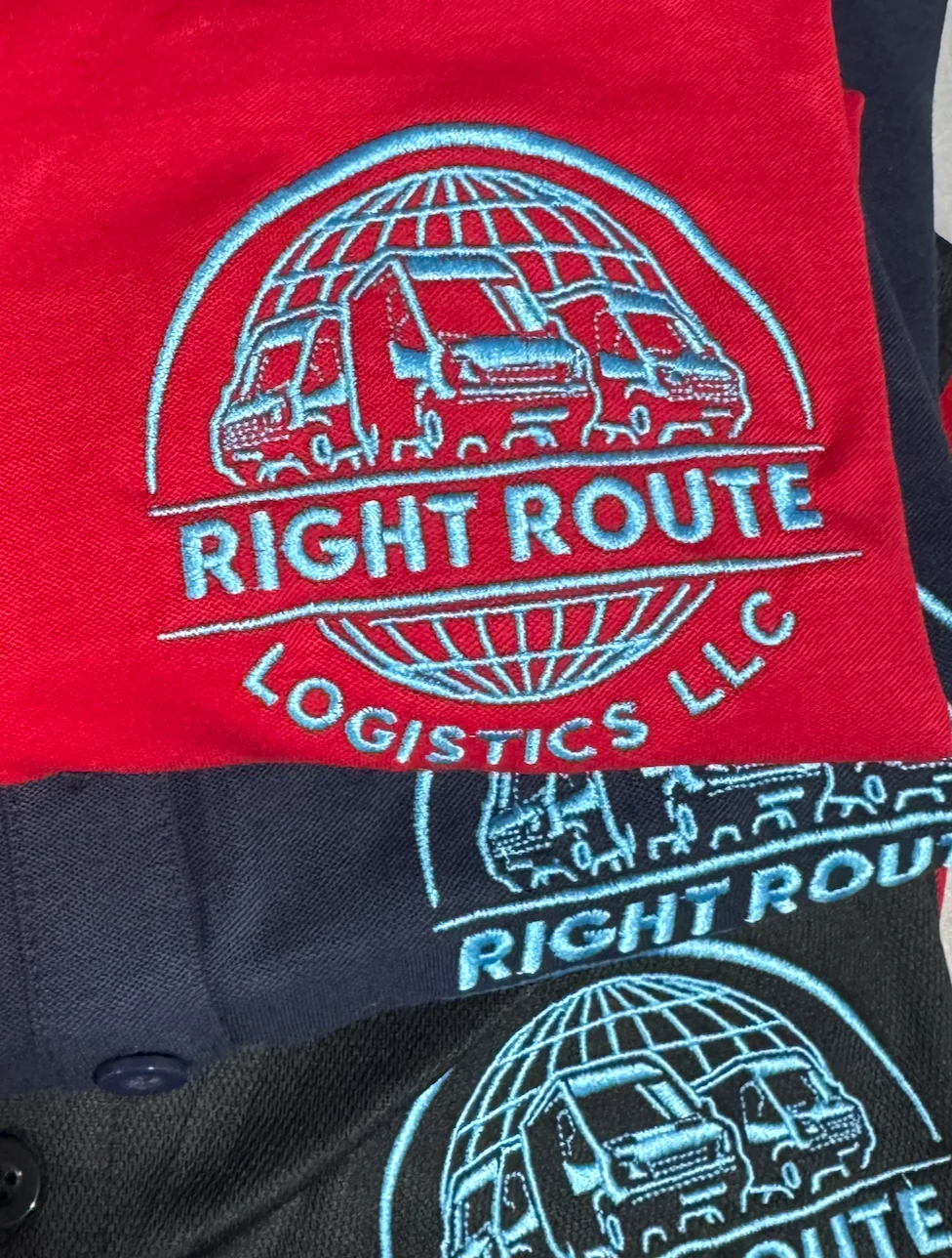 Turquoise truck and logistics logo embroidered on a red and navy business polo with collar and buttons visible
