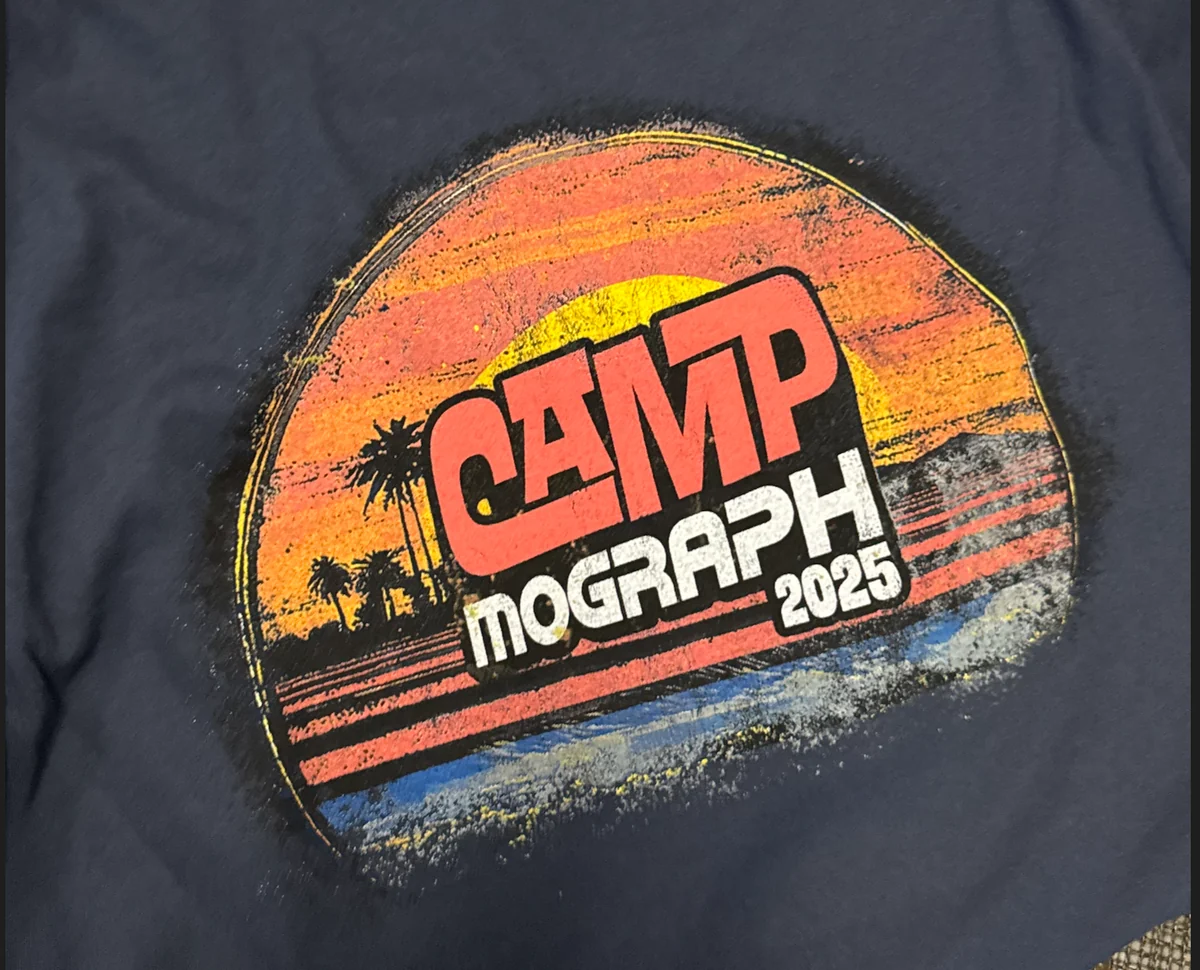 Close-up of a multicolor screen printed Camp Nograph 2025 event shirt