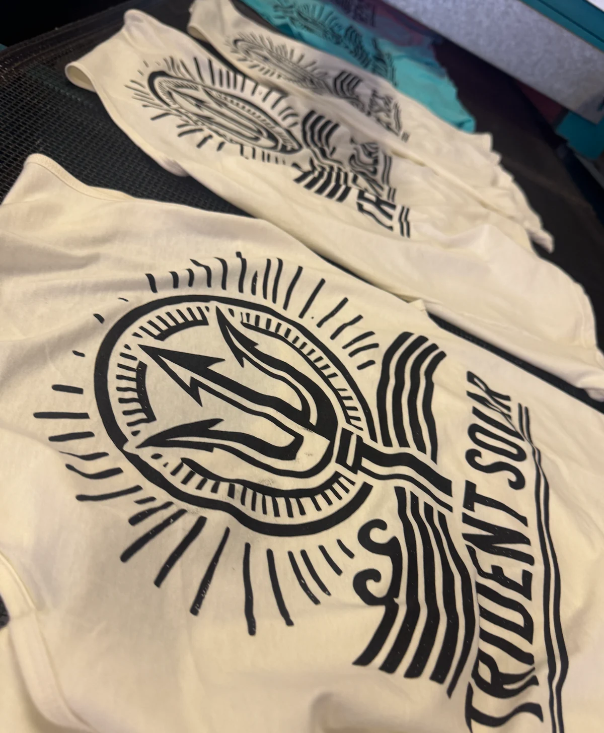 Matching cream and teal single-color screen printed graphic shirts
