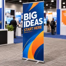Custom retractable banner stand with blue sample graphics at an indoor trade show