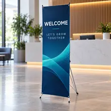 Custom X-banner display with a welcome message in a business lobby