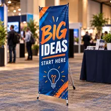 Custom X-banner stand with blue sample graphics at an indoor trade show